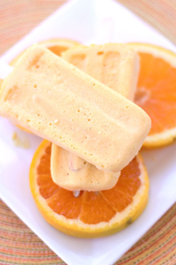 Milk kefir grains are used to ferment heavy cream into a thick sour cream like texture and combined with fresh squeezed orange juice, juicy mangos, vanilla and honey for this Orange Mango Kefir Creamsicle. 